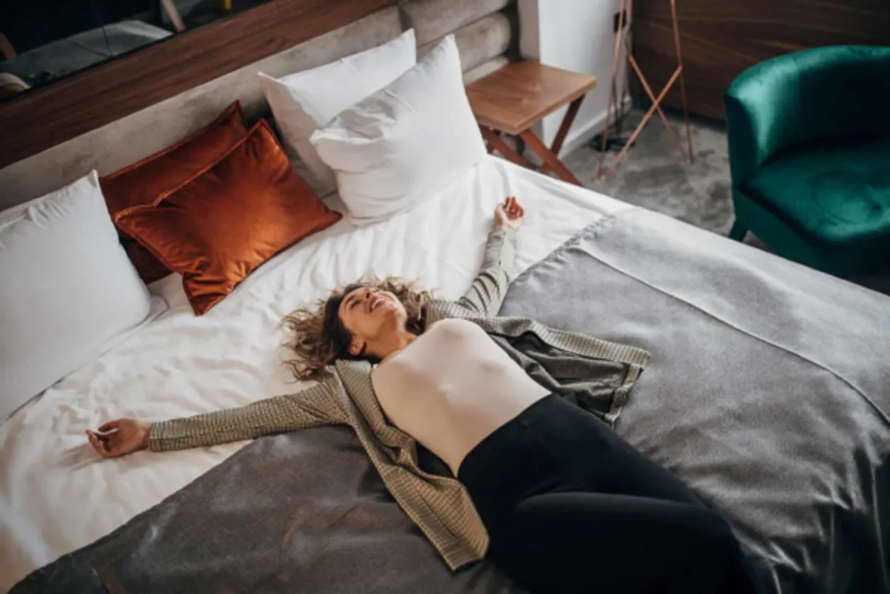 women traveler plopped down on bed trying to beat jet lag